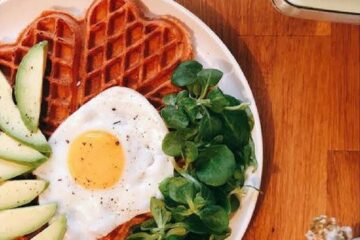 Gaufres salées à la betterave servies avec un œuf au plat, de l'avocat et de la mâche