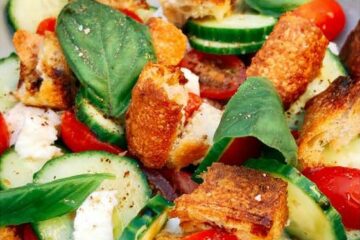 Salade de tomates cerises, concombre, mozzarella, basilic et croûtons de pain grillé