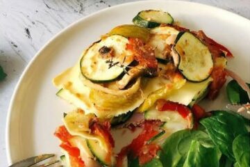 Lasagnes au jambon, courgettes et champignons servies avec des épinards frais